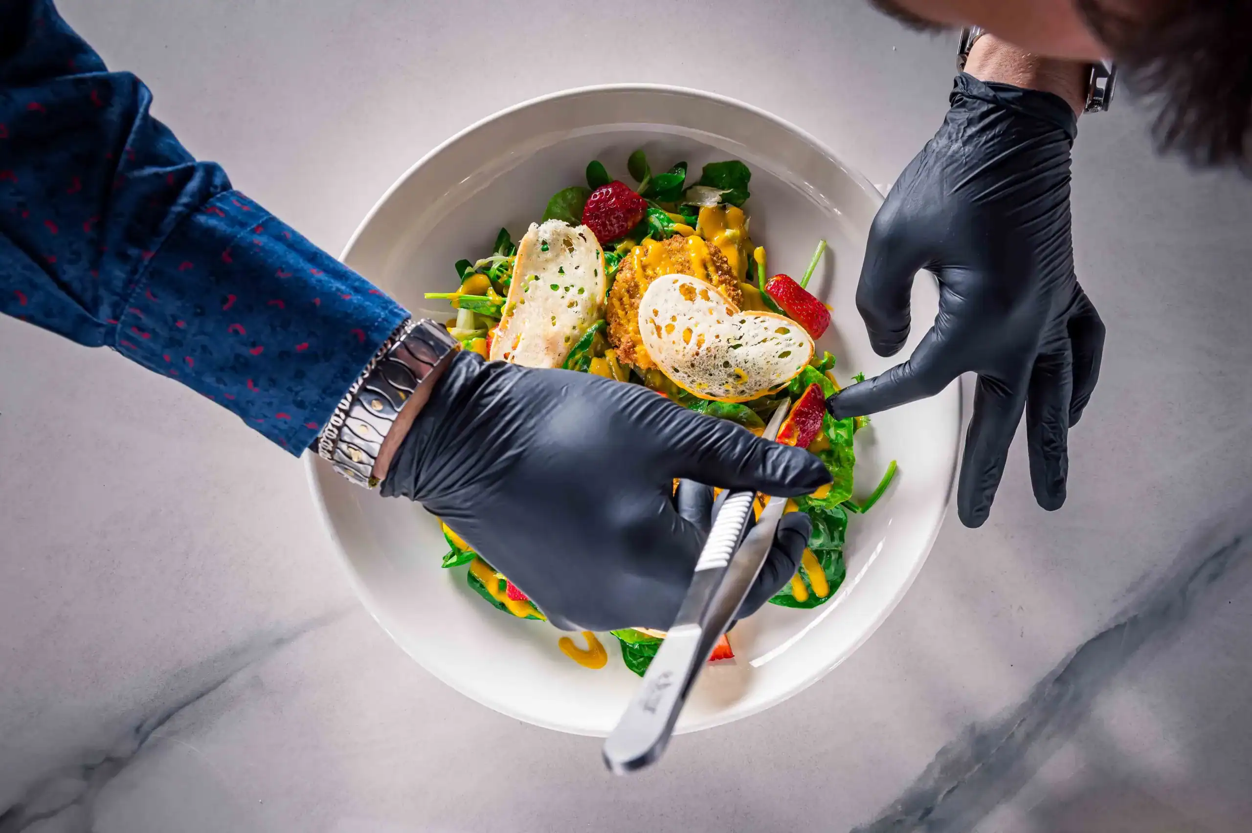 Gourmet salad featuring fresh greens, colorful vegetables, and crispy bread slices on a white plate.