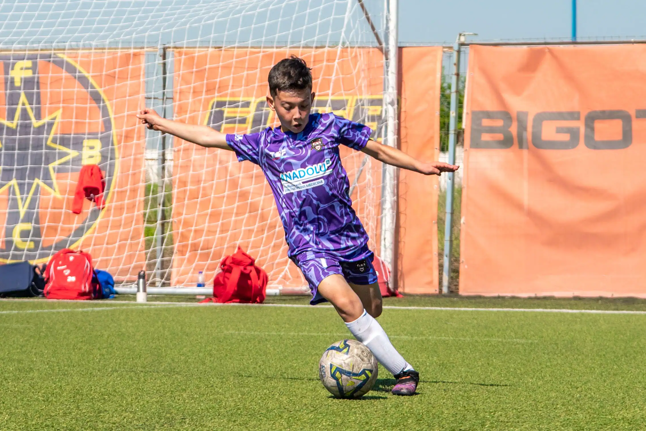 Young soccer player kicking ball during training session.
